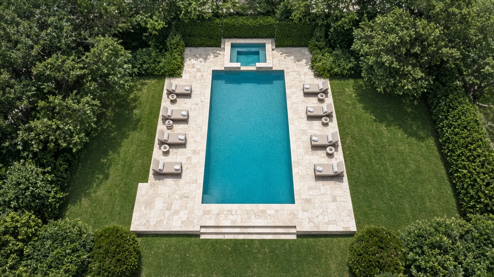 Illustrative top-down aerial of a long rectangular pool with a spa, a pale stone deck and a lawn at midday